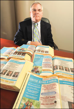 Samster, Konkel & Safran Partner Jerome Konkel is pictured in his office with the firm’s ads in the Yellow Pages. Konkel and other lawyers say they’re seriously reconsidering their investment in the Yellow Pages due to a decline in the quantity and quality of clients they get from the ads. WLJ photo by Kevin Harnack