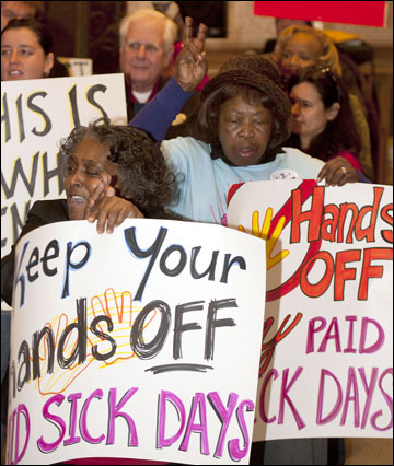 Sherry Johnson (left) and Rosie Caradine-Lewis, both of Milwaukee, hold signs and chant during a rally Thursday at Milwaukee City Hall after an appellate court upheld the city's sick-leave law. (Staff photos by Kevin Harnack)