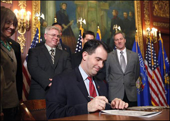 Governor Scott Walker holds a ceremonial signing of his budget repair bill at the state Capitol in Madison on April 6. The bill is an amended version of Walker's original legislation, which repealed most collective bargaining options of public employees. That portion of the bill is facing legal challenges and is stalled in the state's court system. (AP Photo/Wisconsin State Journal, John Hart)