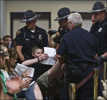 A protester is removed from a meeting of the Joint Committee on Finance at the state Capitol on June 3 in Madison. Many of the people arrested during the protests have yet to pay their fines. (AP Photo/Morry Gash)