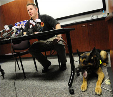 Wounded Fond du Lac police officer Ryan Williams and his partner, K9 officer Grendel, hold a news conference on their first day back on the job on May 9. Williams was shot twice by a sexual assault suspect who killed another officer in March. The suspect eventually committed suicide. A bullet ripped into the Grendel's abdomen while the dog was sitting in a squad car. (AP Photo/The Reporter, Patrick Flood)