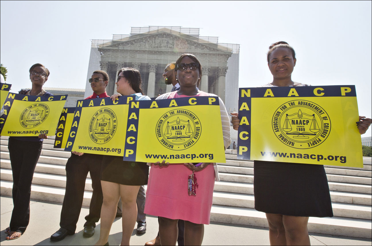 Representatives from the NAACP Legal Defense Fund stand outside the Supreme Court in Washington, Tuesday, June 25, 2013, awaiting a decision in Shelby County v. Holder, a voting rights case in Alabama. The Supreme Court says a key provision of the landmark Voting Rights Act cannot be enforced until Congress comes up with a new way of determining which states and localities require close federal monitoring of elections. (AP Photo/J. Scott Applewhite)