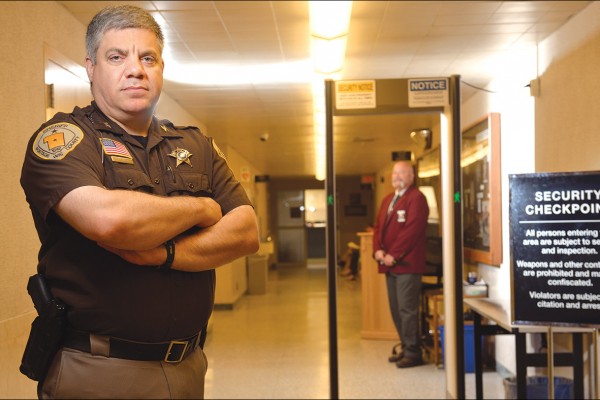 Chief Deputy Daniel Kontos, of the Portage County Sherriff’s Office, stands in front of the secured checkpoint outside of the courtrooms June 27, while Bailiff Michael Baumhofer watches for visitors.