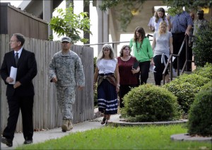 Family members of victims of the Fort Hood shootings are escorted to a news confernence outside the the Lawrence William Judicial Center following the sentencing phase for Maj. Nidal Hasan, Wednesday, Aug. 28, 2013, in Fort Hood, Texas. The jury sentenced Hasan to death. (AP Photo/Eric Gay)