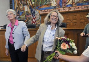 Liz Stefonics, left, and Linda Siegle, a lobbyist for Equality New Mexico, hold hands after they were married in the Santa Fe County Commission Chambers, Friday Aug. 23, 2013 in Santa Fe, N.M. The county clerk in the New Mexico state capital and the heart of this state's gay rights movement began issuing marriage licenses to gay and lesbian couples Friday, a court-ordered move that came just two days after a county clerk on the other end of the state decided on his own to recognize same-sex marriage. (AP Photo/The Albuquerque Journal, Eddie Moore)
