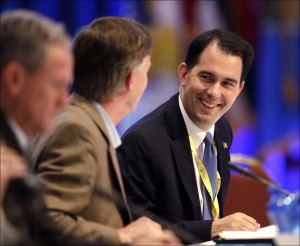 Wisconsin Gov. Scott Walker (right) talks to Colorado Gov. John Hickenlooper during a session of the National Governors Association meeting Sunday in Milwaukee. Walker spared two UW-Madison projects Tuesday from cuts to the state’s construction budget. (AP Photo/Morry Gash)