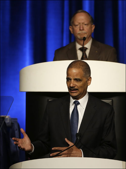 Attorney General Eric Holder, below, speaks to the American Bar Association Annual Meeting as chair Robert Carlson, top, listens Monday, Aug. 12, 2013, in San Francisco. In remarks to the association, Holder said the Obama administration is calling for major changes to the nation's criminal justice system that would cut back the use of harsh sentences for certain drug-related crimes. (AP Photo/Eric Risberg)