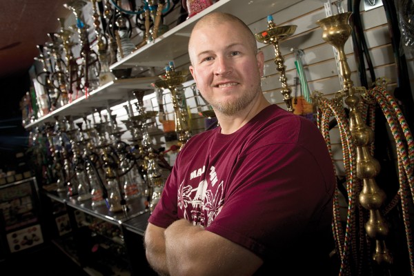 Jason Clark, owner of Smokes on State, stands in front of hookahs for sale at his Madison shop