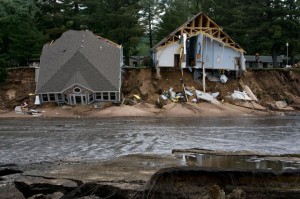 Two houses fall into an emptied Lake Delton on June 10, 2008. (AP File Photo/Andy Manis)