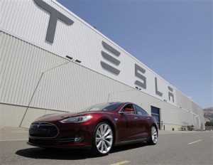 a Tesla Model S driving outside the Tesla factory in Fremont, Calif. Electric-car company Tesla Motors has filed notice it intends to sue New Jersey over a ruling that would stop it from selling its vehicles in the state within two weeks. Palo Alto, Calif.-based Tesla claims it was unfairly targeted in March 2014 when the state Motor Vehicle Commission amended its regulations. The regulations require new-car dealers to have franchise agreements before they can be licensed. That prohibits companies from using a direct-sales model as Tesla does. (AP Photo/Paul Sakuma, File)