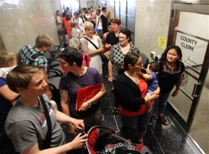Same-sex couples congregate outside the Dane County Clerk's office in Madison, Wis., as they wait to file paperwork to get married Friday, June 6, 2014. Earlier in the day, a federal judge overturned the state's ban on same-sex marriages. (AP Photo/Wisconsin State Journal, John Hart)