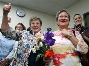 Miriam Douglass, left, and Ligia Rivera react Monday, June 9, 2014 to the announcement that marriage licenses would be granted, subject to a five day waiting period, in Outagamie County, Wis. The two were given the first same-sex marriage license in the county. Attorney General J.B. Van Hollen on Monday asked a federal appeals court to halt gay weddings in Wisconsin after a judge declared the state's ban on same-sex marriages unconstitutional. U.S. District Judge Barbara Crabb struck down the state's ban on Friday, but her ruling caused confusion because she didn't specifically tell county and state officials whether they could issue marriage licenses to same-sex couples. Clerks in Madison and Milwaukee immediately began issuing licenses. (AP Photo/The Post-Crescent, Wm.Glasheen)