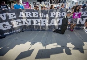 Michael Hichborn kneels and prays as he joins demonstrators while waiting for the Supreme Court's decision on the Hobby Lobby case outside the Supreme Court in Washington, Monday, June 30, 2014. The Supreme Court says corporations can hold religious objections that allow them to opt out of the new health law requirement that they cover contraceptives for women.(AP Photo/Pablo Martinez Monsivais)