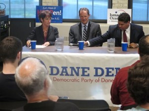 Dane County District Attorney Ismael Ozanne, right, passes a microphone to Jefferson County District Attorney Susan Happ, left, on Tuesday, July 22, 2014, at a forum in Madison, Wis., for all three Democratic candidates for Wisconsin attorney general, as state Rep. Jon Richards, center, watches. The candidates will square off in a primary Aug. 12. (AP Photo)