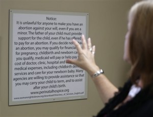 South Wind Women’s Center executive director Julie Burkhart talks about notices, which by law have to be shown to women seeking abortions before having the procedure at the clinic in Wichita, Kan. In more than a dozen states, opponents of abortion have introduced bills requiring that doctors at abortion clinics have admitting privileges at nearby hospitals. (AP Photo/Charlie Riedel, File)