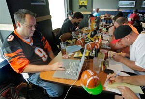 In this Aug. 30, 2010 photograph, Brian Sherman, left, uses his laptop to record moves in his team's fantasy football draft, at a Buffalo Wild Wings restaurant in Cincinnati. Some restaurant chains around the country have launched promotional drives to score with dedicated players of the growing pastime. (AP Photo/Al Behrman)