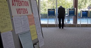 a lone voter takes part in early voting in Milwaukee. The Supreme Court deals with churning election rules in several states less than a month from November's voting, blocking voter ID laws in Wisconsin while siding with Republicans for stricter rules in North Carolina and Ohio. In Texas, a federal court strikes down a voter ID law, but the state may still appeal that ruling. (AP Photo/Morry Gash)