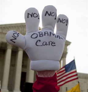 Janis Haddon of Atlanta holds her glove high outside the United States Supreme Court in Washington, Wednesday, March 28, 2012, as the court concludes three days of hearing arguments on the constitutionality of President Barack Obama's health care overhaul, the Patient Protection and Affordable Care Act. Nearly five years after President Barack Obama signed his health care overhaul into law, the Supreme Court will again get to decide its fate. (AP Photo/Carolyn Kaster)