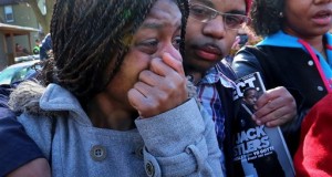 Kyrisha Isom, left, weeps with Derrick McCann during a rally protesting the shooting death of Tony Robinson, Saturday, March 7, 2015, in Madison, Wis. Robinson, an unarmed black 19-year-old, was fatally shot Friday by Matt Kenny, a white police officer, the Madison police chief said Saturday, March 7, 2015. Isom said she had been friends with Robinson for about 12 years. (AP Photo/Wisconsin State Journal, John Hart)
