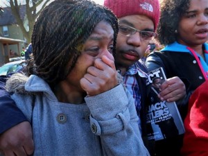 Kyrisha Isom, left, weeps with Derrick McCann during a rally protesting the shooting death of Tony Robinson, Saturday, March 7, 2015, in Madison, Wis. Robinson, an unarmed black 19-year-old, was fatally shot Friday by Matt Kenny, a white police officer, the Madison police chief said Saturday, March 7, 2015. Isom said she had been friends with Robinson for about 12 years. (AP Photo/Wisconsin State Journal, John Hart)