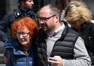 Judge Fernando Ciampi's wife, left, one victim of the shooting, leaves the tribunal building in Milan, Italy, after a shooting erupted inside a courtroom Thursday, April 9, 2015. A man on trial for fraudulent bankruptcy opened fire in Milan's courthouse Thursday, killing his lawyer, a co-defendant and a judge before being captured nearly 25 kilometers away as he fled on a motorbike, officials said. (AP Photo/Daniel Dal Zennaro, ANSA)