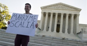 Ryan Aquilina, 24, of Washington holds a sign in front of the Supreme Court in Washington, Tuesday, April 28, 2015. The Supreme Court is set to hear historic arguments in cases that could make same-sex marriage the law of the land. The justices are meeting Tuesday to offer the first public indication of where they stand in the dispute over whether states can continue defining marriage as the union of a man and a woman, or whether the Constitution gives gay and lesbian couples the right to marry. (AP Photo/Cliff Owen)