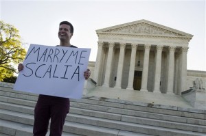 Ryan Aquilina, 24, of Washington holds a sign in front of the Supreme Court in Washington, Tuesday, April 28, 2015. The Supreme Court is set to hear historic arguments in cases that could make same-sex marriage the law of the land. The justices are meeting Tuesday to offer the first public indication of where they stand in the dispute over whether states can continue defining marriage as the union of a man and a woman, or whether the Constitution gives gay and lesbian couples the right to marry. (AP Photo/Cliff Owen)