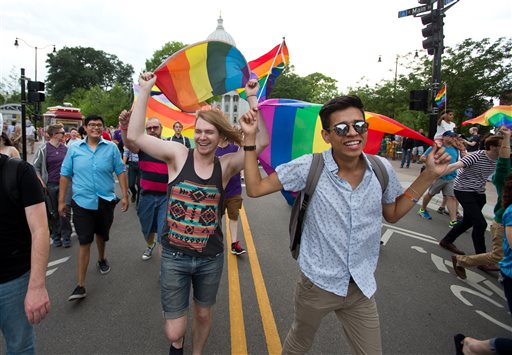 A.J. Blanchet, middle left, of Madison, and Dallas Peters, right, of Madison, march down King Street in Madison, Wis., during a rally Friday, June 26, 2015. Gay marriage has been legal in Wisconsin for months, but supporters still trumpeted a U.S. Supreme Court ruling Friday legalizing same-sex marriage nationwide with relief and joy, saying it cements same-sex unions in the state. (AP Photo/Wisconsin State Journal, Steve Apps)