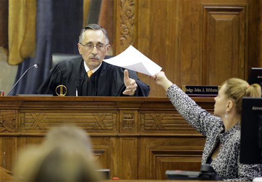Milwaukee County Circuit Judge John DiMotto presides over court after a verdict was read, Tuesday, Oct. 13, 2015, in Milwaukee, in a negligence lawsuit filed by two Milwaukee police officers who were shot and seriously wounded by a gun purchased at a Wisconsin gun store. Jurors ordered the gun store, Badger Guns, to pay nearly $6 million in damages. The lawsuit alleges the shop allowed an illegal sale despite several warning signs that the gun was being sold to a "straw buyer," or someone who was buying the gun for someone who couldn't legally do so. (Mike De Sisti/Milwaukee Journal-Sentinel via AP)