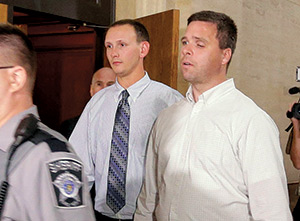 Former Milwaukee police officers Graham Kunisch (right) and Bryan Norberg, who were shot and seriously wounded by a gun purchased at a Wisconsin gun store, leave a Milwaukee court Oct. 13 after jurors ordered the gun store to pay nearly $6 million in damages. The ruling came in a negligence lawsuit filed against the store, Badger Guns, by the two officers.