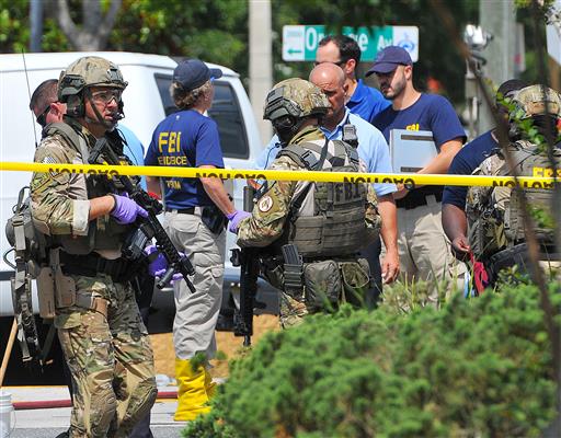 FBI, Orlando Police Department and personnel from the Orange County Sheriff's Office investigate the attack at the Pulse nightclub in Orlando, Fla. New reports show that law enforcement officials immediately suspected terrorism and adjusted their staging areas due to fears about an explosive device as they responded to reports of shots fired at the gay nightclub in Orlando. In incident reports released Saturday, June 25, Orange County Sheriff's Office deputies describe receiving limited information about an "active shooter" as they rushed to control the chaos outside Pulse on June 12. (Craig Rubadoux/Florida Today via AP, File)