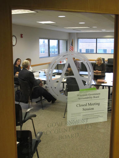 Members of the newly created Wisconsin Ethics Commission meet in closed session with staff of the Government Accountability Board on Thursday, June 9, 2016, in Madison, Wisc. The new partisan Ethics Commission, and one focused on elections, will replace the nonpartisan GAB on June 30, requiring a reorganization and removal of the old logo from the meeting room door. (AP Photo/Scott Bauer)