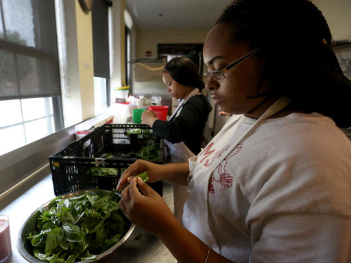 Ivanah Atkinson, of Sun Prairie, peels basil during a teen employment program at the Goodman Community Center in Madison. (Michelle Stocker /The Capital Times via AP)