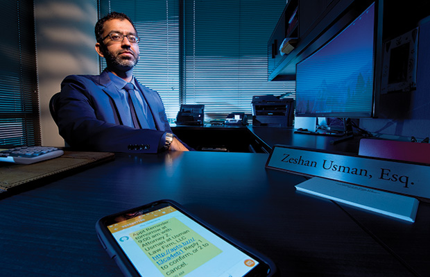 A text notification appears on Zeshan Usman’s phone while in his Madison office. The personal-injury and debt-relief lawyer uses several basic technologies to stay effective. (Staff photo by Kevin Harnack)