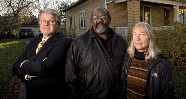 Attorney Alex Flynn (left) stands with his clients, Taft and Carol Parsons, in front of their home on Stark Street in Milwaukee. Parsons tried to redevelop part of their neighborhood at 46th Street and Hampton Avenue into townhouses, but a contractor and loan officer, both of whom later pleaded guilty to a bank fraud scheme, left them with thousands of dollars in debt and not even a building permit to show for it. The Parsons have sued the bank that issued them the loans for the project in order to recover the money they lost. (Staff photo by Kevin Harnack)