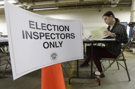 Nicole Kirby looks over results during a statewide presidential election recount Thursday, Dec. 1, 2016, in Milwaukee. The first candidate-driven statewide recount of a presidential election in 16 years began Thursday in Wisconsin, a state that Donald Trump won by less than a percentage point over Hillary Clinton after polls long predicted a Clinton victory. (AP Photo/Morry Gash)