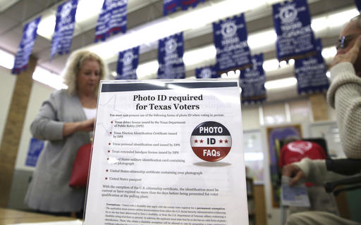 FILE - In this March 1, 2016, file photo, a sign tells voters of voter ID requirements before participating in the primary election at Sherrod Elementary school in Arlington, Texas. Attorneys challenging tough voter ID laws in Texas and North Carolina say they’ll keep pressing their lawsuits without the support of President Donald Trump’s Justice Department if necessary. Trump announced Wednesday, Jan. 25, 2017, that he is ordering a “major investigation” into voter fraud, which tough laws requiring photo identification at the ballot box are designed to prevent. (AP Photo/LM Otero, File)