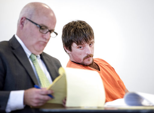 Joseph Jakubowski, right, glances over toward his attorney, Michael Murphy, left, on Tuesday, April 25, 2017, during his preliminary hearing at the Rock County Courthouse in Janesville, Wis. Prosecutors say Jakubowski mailed a rambling manifesto to President Donald Trump then stole 18 firearms from a store in Janesville on April 4. He was arrested 10 days later while camping on private property in southwestern Wisconsin, about 140 miles from Janesville. Jakubowski pleaded not guilty to state charges later Tuesday. (Angela Major/The Janesville Gazette via AP)