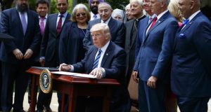 President Donald Trump signs an executive order aimed at easing an IRS rule limiting political activity for churches, Thursday, May 4, 2017, in the Rose Garden of the White House in Washington. (AP Photo/Evan Vucci)