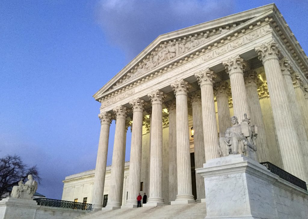 FILE - In this Feb. 13, 2016, file photo, people stand on the steps of the Supreme Court at sunset in Washington. The Trump administration made a plea to the Supreme Court on June 1, 2017, to let travel ban take effect (AP Photo/Jon Elswick, file)
