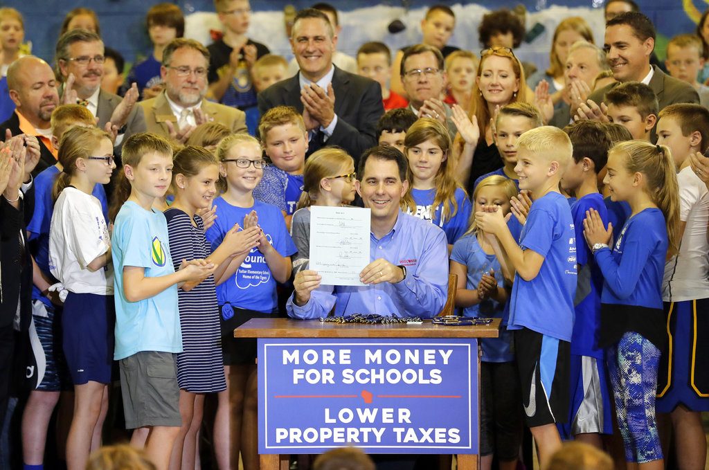Governor Scott Walker signs the 2017-2019 state budget bill into law Thursday, Sept. 21, 2017, at Tullar Elementary School in Neenah, Wis. (Dan Powers/The Post-Crescent via AP)