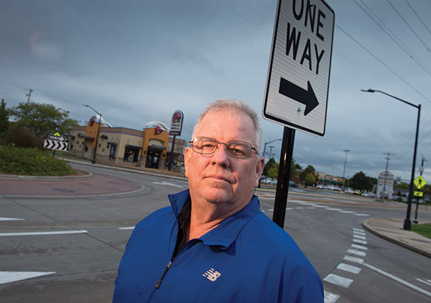 J.C. Johnson, an appraiser from Cottage Grove, stands across from a roundabout that is at the center of a dispute going before the state Supreme Court. Johnson has testified that abutting property owners should not have to pay for improvements related to the roundabout, arguing that the project has not been a benefit to nearby property owners.