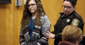 FILE - In this Dec. 21, 2017, file photo, Anissa Weier, one of two Wisconsin girls who tried to kill a classmate to win favor with a fictional horror character named Slender Man, is led into Court for her sentencing hearing, in Waukesha, Wis. She was sentenced to 25 years in a mental hospital, the maximum punishment possible. Their cases were selected as one of the biggest stories in the state over the last 12 months. (Michael Sears/Milwaukee Journal-Sentinel via AP, File)