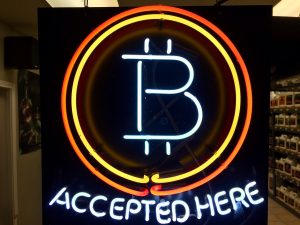 A neon sign hanging in February in the window of Healthy Harvest Indoor Gardening in Hillsboro, Ore., shows that the business accepts bitcoin as payment. The Wisconsin Ethics Commission is considering a policy that would govern political contributions made in bitcoin and other cryptocurrencies. (AP Photo/Gillian Flaccus File)