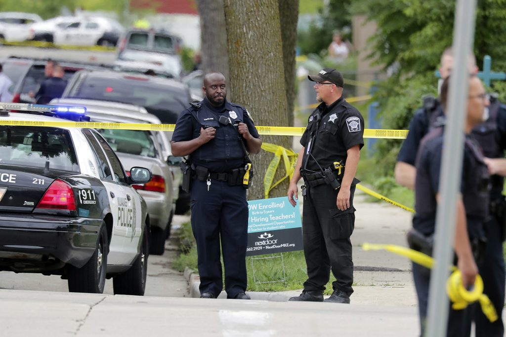 Authorities investigate the scene where a Milwaukee Police officer was fatally shot, Wednesday, July 25, 2018, in Milwaukee. A suspect is in custody. (Mike De Sisti/Milwaukee Journal-Sentinel via AP)