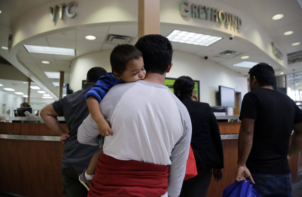FILE - In this June 21, 2018, file photo, a group of immigrants from Honduras and Guatemala seeking asylum stand in line at the bus station after they were processed and released by U.S. Customs and Border Protection in McAllen, Texas. The American Civil Liberties Union is suing the U.S. government over its effort to restrict immigrants from seeking asylum on the grounds that they would suffer domestic or gang violence in their countries of origin. (AP Photo/Eric Gay, File)