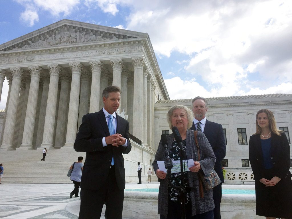 Pennsylvania resident Rose Mary Knick speaks outside the Supreme Court, Wednesday, Oct. 3, 2018 in Washington, alongside her attorneys J. David Breemer, left, Brian Hodges and Christina Martin. Knick is at the center of a case the Supreme Court is hearing that stems from her dispute with her town over an ordinance that says landowners who have cemeteries on their properties must make them open to the public during daylight hours. (AP Photo/Jessica Gresko)