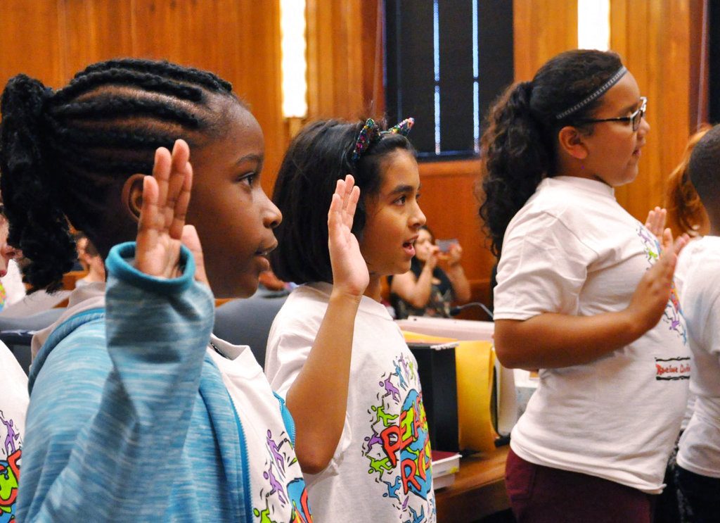 ADVANCE FOR MONDAY, OCT. 22 AND THEREAFTER Peer mediator 1: Jasmine Kinchen, left, a fifth-grade student at Gilmore Fine Arts School in Racine, at left, along with Raimee McCray, center, a fourth-grade student also at Gilmore Fine Arts, take the peer mediator oath on Monday, Oct. 8, 2018 at the Racine County Courthouse in Racine, Wis. (Pete Wicklund/The Journal Times via AP)