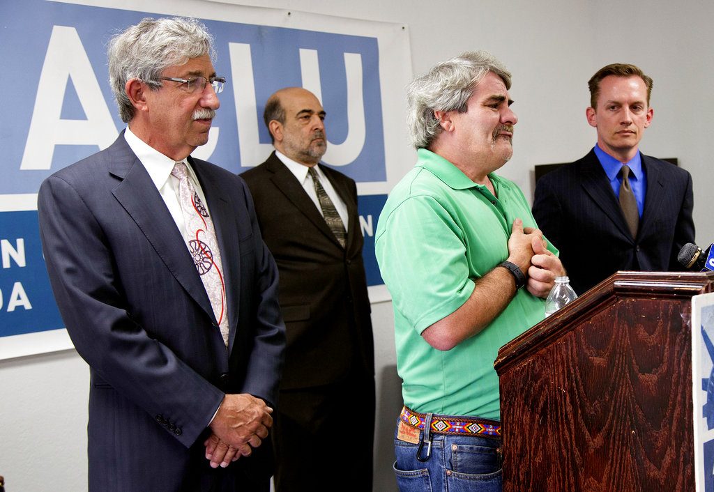 File - In this June 12, 2013 file photo, surrounded by attorneys, Mark Merin, Allen Lichtenstein and Tod Story, lead plaintiff James Flavy Coy Brown, second from right, talks during a news conference at the ACLU headquarters in Las Vegas. A Nevada jury has put the state and a mental hospital administrator on the hook for close to $9 million in class-action damages for sending patients unaccompanied to states including California, Florida and Michigan. An eight-woman civil jury decided Thursday, Nov. 1, 2018, that every Rawson-Neal Psychiatric Hospital patient who was given a bus ticket to another city and no other arrangements for care after June 2011 should receive $250,000. Damages could top $22 million, according to attorney Mark Merin. He represents lead plaintiff James Flavy Coy Brown of Sacramento. (AP Photo/Julie Jacobson, File)