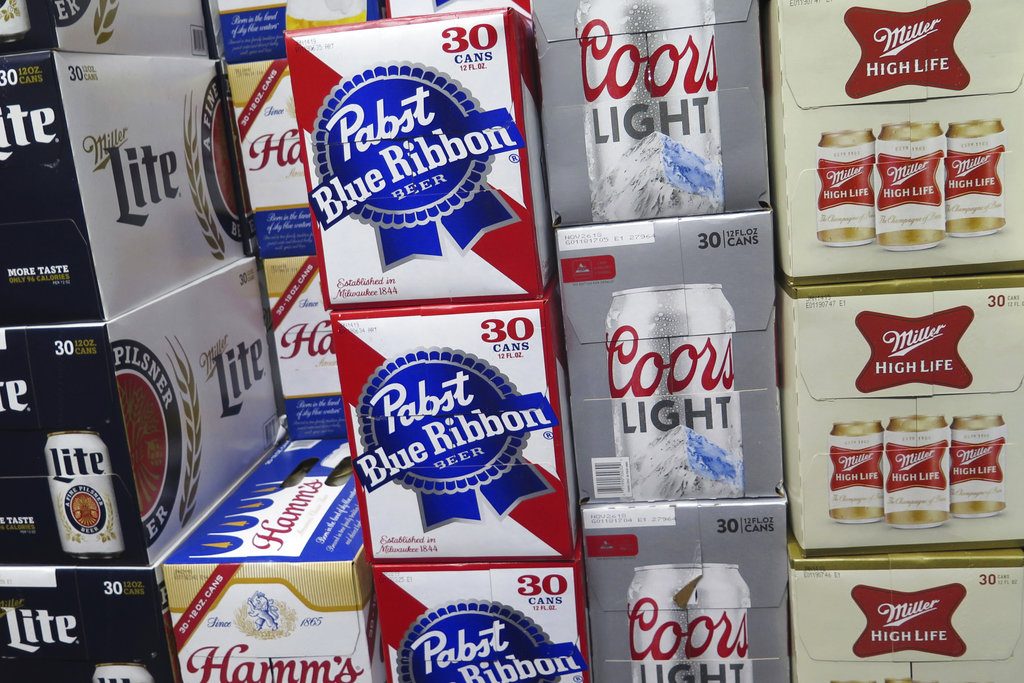 FILE - In this Nov. 8, 2018, file photo, cases of Pabst Blue Ribbon and Coors Light are stacked next to each other in a Milwaukee liquor store. MillerCoors and Pabst Brewing Co. settled a lawsuit Wednesday, Nov. 28, in which the hipster’s brand of choice claimed the bigger brewer lied about its ability to continue brewing Pabst's beers to put that company out of business. (AP Photo/Ivan Moreno, File)